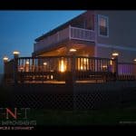 deck w/ seating, lighting, hot tub, & fireplace (nighttime)